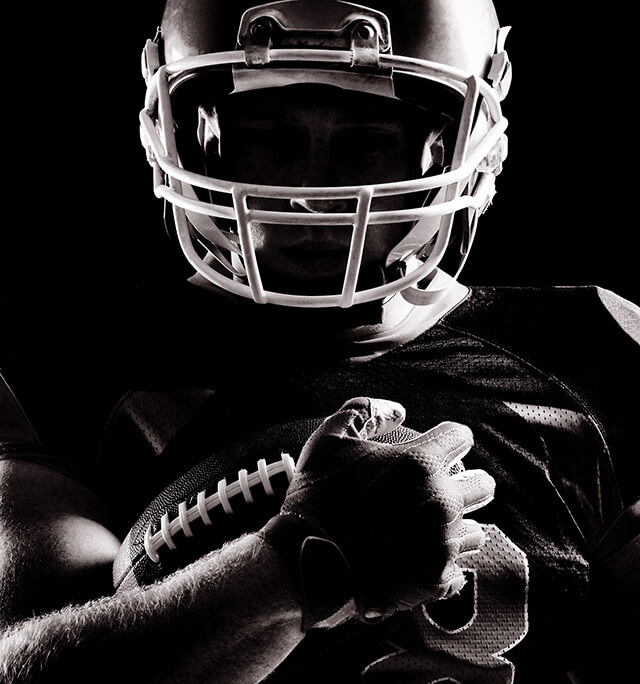 Dramatically Lit Player Holding a Football